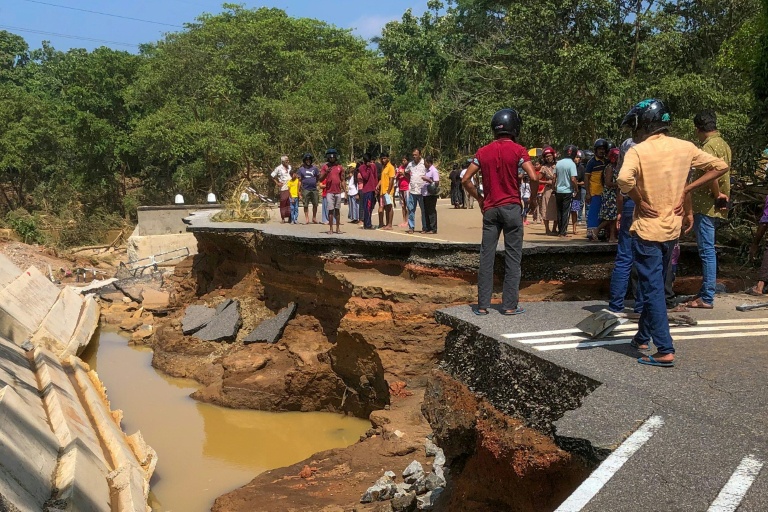 Des habitants se tiennent près d'un pont endommagé par les inondations, le 30 novembre 2025 à Kurunegala au Sri Lanka