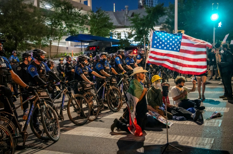 Des manifestants opposés aux politiques de Donald Trump face à des policiers, lors d'un rassemblement