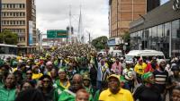 Des milliers de manifestants, appelés à défiler par l'ANC, traversent l'emblématique pont Nelson Mandela de Johannesburg le 21 mars 2026.