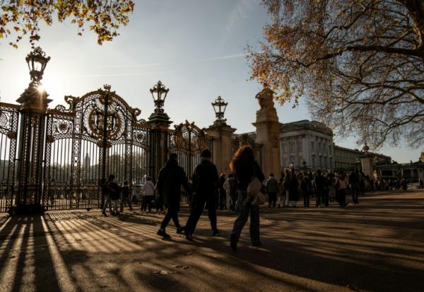 Des passants devant l'entrée du palais de Buckingham à Londres, le 21 novembre 2025