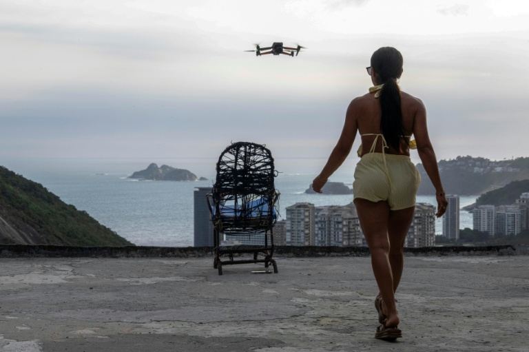Une touriste se fait filmer par un drone sur le toit d'une maison dans la favela de Rocinha, à Rio de Janeiro, au Brésil, le 5 mars 2026