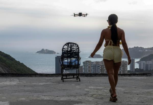 Une touriste se fait filmer par un drone sur le toit d'une maison dans la favela de Rocinha, à Rio de Janeiro, au Brésil, le 5 mars 2026