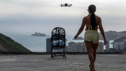 Une touriste se fait filmer par un drone sur le toit d'une maison dans la favela de Rocinha, à Rio de Janeiro, au Brésil, le 5 mars 2026