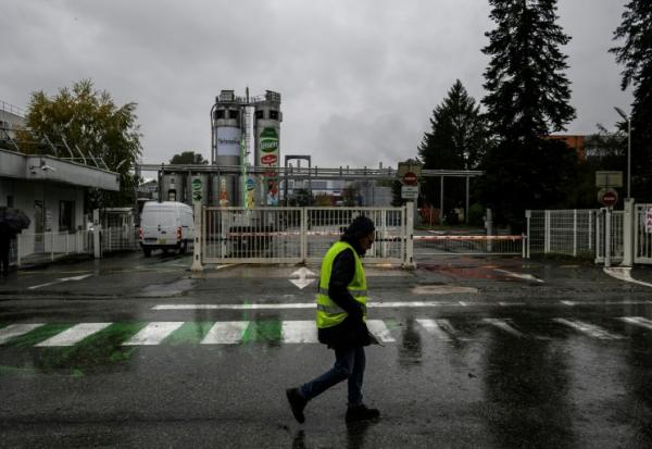 Un employé de Teisseire passe devant l'entrée du site de production du fabricant français de sirops à Crolles, près de Grenoble, dont la fermeture a été annoncée par l'entreprise, en même temps qu'un plan de réorganisation entraînant la suppression de près de 170 emplois, le 20 octobre 2025.