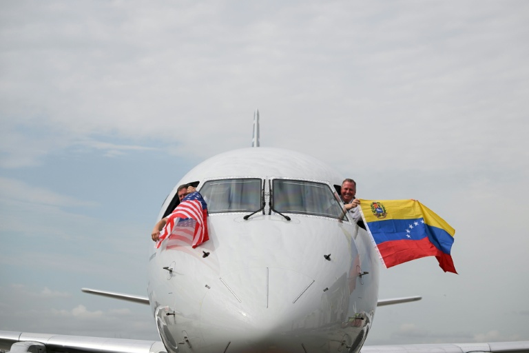 Les pilotes du vol 3599 d'American Airlines, reliant l'aéroport international de Miami à Caracas, au Venezuela, agitent des drapeaux vénézuéliens et américains avant de décoller pour un vol direct vers le Venezuela, le premier entre les États-Unis et le Venezuela en sept ans, le 30 avril 2026 à l'aéroport international de Miami, en Floride