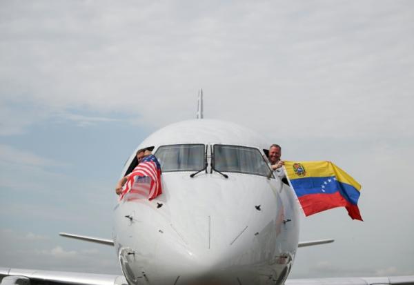 Les pilotes du vol 3599 d'American Airlines, reliant l'aéroport international de Miami à Caracas, au Venezuela, agitent des drapeaux vénézuéliens et américains avant de décoller pour un vol direct vers le Venezuela, le premier entre les États-Unis et le Venezuela en sept ans, le 30 avril 2026 à l'aéroport international de Miami, en Floride