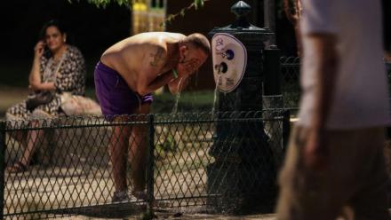 Un homme se rafraîchit à une fontaine publique près du Canal Saint-Martin à Paris en pleine canicule, le 25 juin 2026