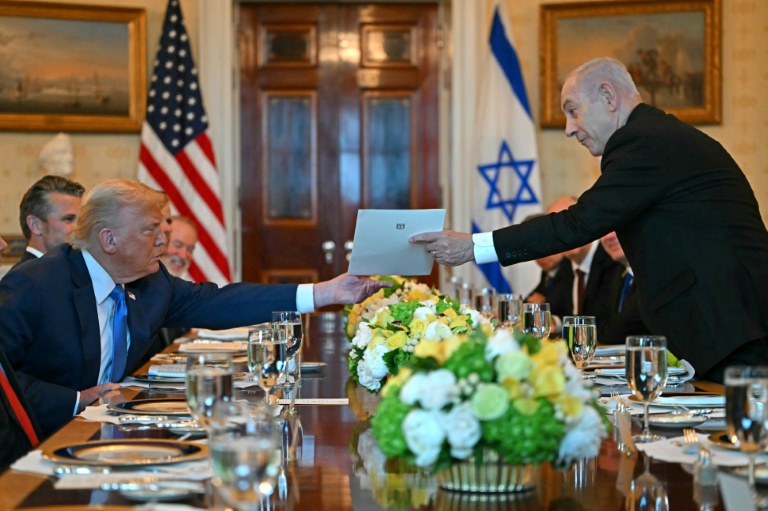 Le Premier ministre israélien Benjamin Netanyahu remet une lettre au président américain Donald Trump lors de leur rencontre à la Maison Blanche à Washington, le 7 juillet 2025