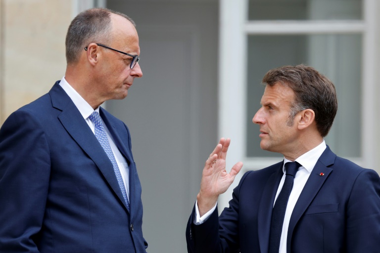 Le président français Emmanuel Macron (d) s'entretient avec le chancelier allemand Friedrich Merz dans le jardin du palais de l'Elysée à Paris, le 7 mai 2025