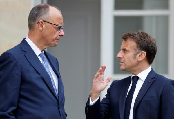Le président français Emmanuel Macron (d) s'entretient avec le chancelier allemand Friedrich Merz dans le jardin du palais de l'Elysée à Paris, le 7 mai 2025