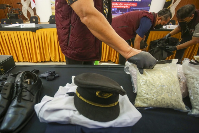 Des agents des douanes présentent l'uniforme d'un pilote ainsi que la drogue qu'il a fait passer en contrebande, lors d'une conférence de presse à l'aéroport international Soekarno-Hatta de Tangerang, près de Jakarta, le 31 juillet 2026 en Indonésie