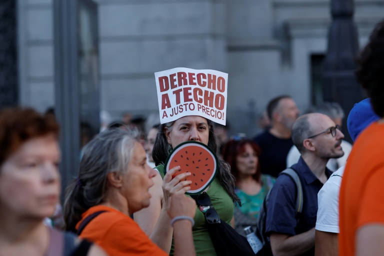 Un manifestant tient une pancarte portant l'inscription « Droit à un toit à un prix équitable » lors d'une manifestation contre les expulsions et la crise du logement sur la Puerta del Sol à Madrid, le 26 septembre 2026