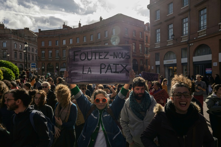 Une manifestante tient une pancarte sur laquelle on peut lire 