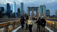 Des passants bravent le froid en traversant le pont de Brooklyn, dans le quartier de Manhattan à New York, le 21 janvier 2026