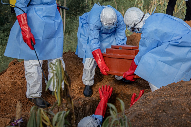 Des volontaires déposent le cercueil d’un enfant de 3 ans, présumé mort d'Ebola, lors de ses funérailles dans un cimetière de Bunia, le 11 juin 2026 en RDC