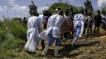 Des agents de santé, équipés de vêtements de protection, transportent vers le cimetière le cercueil d'une personnes suspectée d'avoir succombé à la maladie d'Ebola, à Bunia, dans l'est de la République démocratique du Congo, le 25 mai 2026