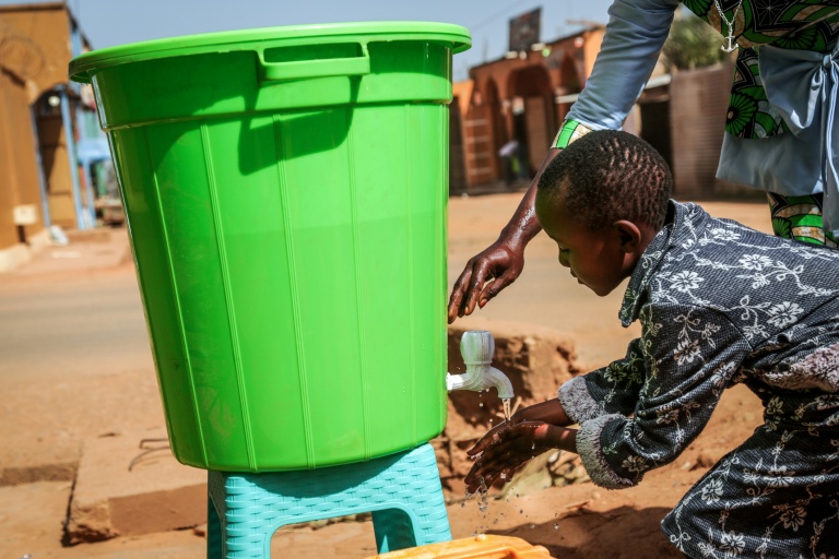 Une fillette se lave les mains avant d'entrer dans une église, suivant les instructions données par les autorités sanitaires pour limiter la propagation du virus Ebola, à Bunia, en République démocratique du Congo, le 24 mai 2026