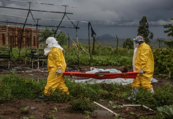 Du personnel médical transporte un patient sur un brancard à l'hôpital de Rwampara, le 21 mai 2026, en OUganda, tout près de la République Démocratique du Congo, touchée par une épidémie d'Ebola