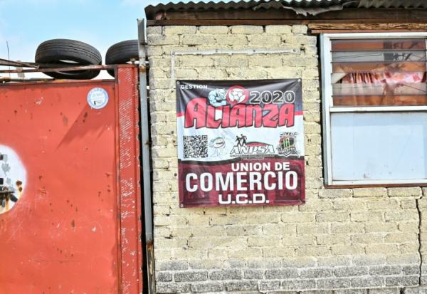 Une affiche sur le mur d'une entreprise indique un signe d'affiliation payante à des groupes qui garantissent la sécurité contre l'extorsion à Ecatepec, dans l'État de Mexico, le 2 octobre 2025