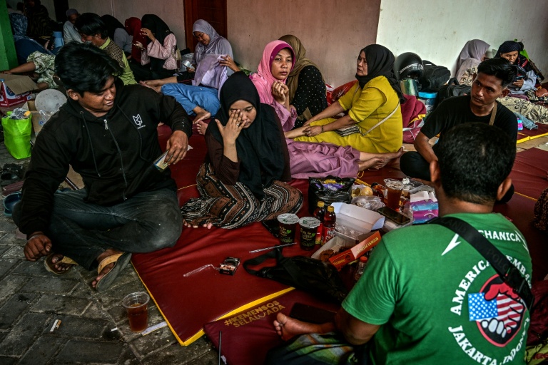 Des proches d'élèves disparus attendent des nouvelles pendant les recherche de victimes à l'école islamique Al Khoziny à Sidoarjo, dans la province de Java oriental, après l'effondrement d'un bâtiment pendant les prières, le 5 octobre 2025 en Indonésie