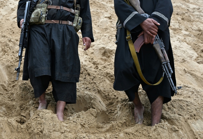 Des personnels de sécurité talibans surveillent le site de loisirs situé sur la pente sableuse de la montagne Reg-e-Rawan dans la région de Sayad, le 24 avril 2026, en Afghanistan