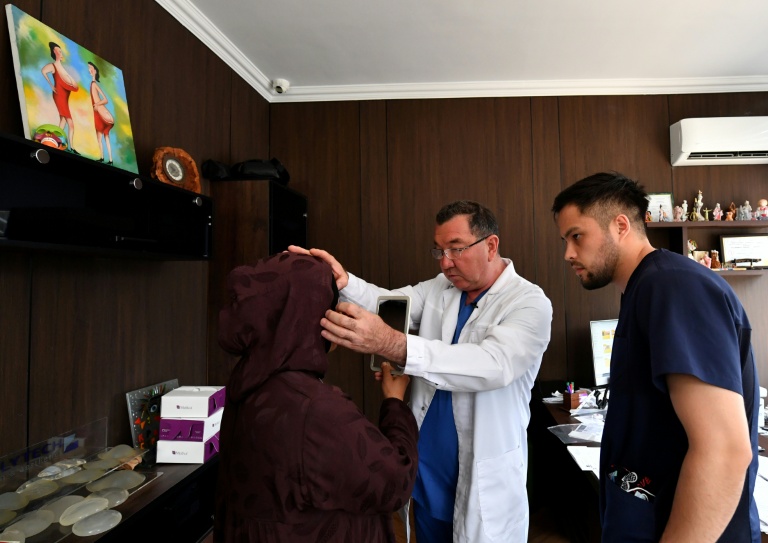 Le chirurgien esthétique Iskender Katchkinbaïev examine une patiente à Bichkek, le 18 mai 2026 au Kirzghizstan