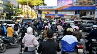 Des motocyclistes font la queue pour faire le plein d'essence dans une station-service à Hanoï, le 10 mars 2026 au Vietnam