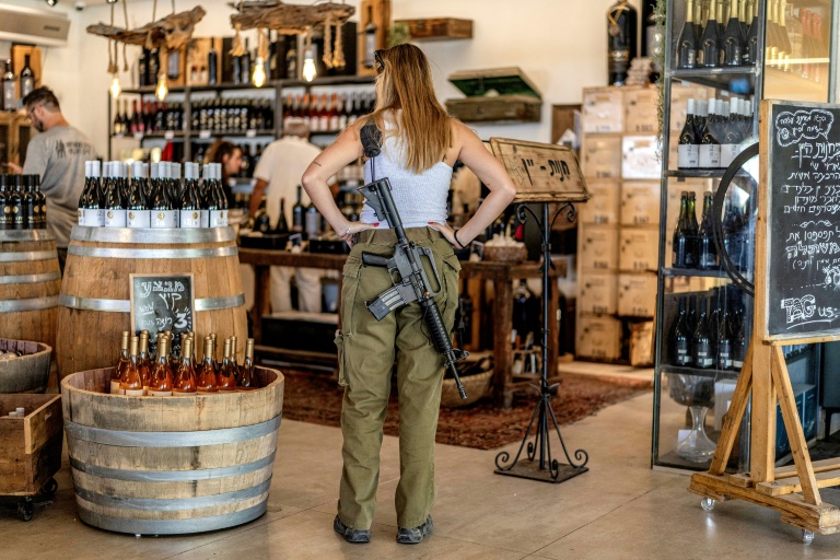 Une soldate de l'armée israélienne regarde des bouteilles de vin en vente dans une exploitation viticole de la colonie israélienne de Shaar Binyamin, au sud-est de Ramallah, le 9 septembre 2026 en Cisjordanie occupée