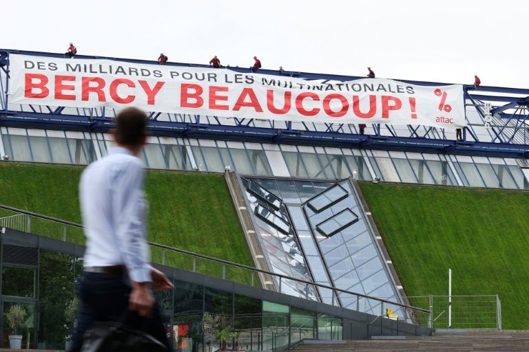 Des militants de l'organisation Attac France déploient une banderole sur la salle de spectacles Accor Arena à Paris mardi 2 juin 2026, protestant contre les aides publiques aux multinatinales 