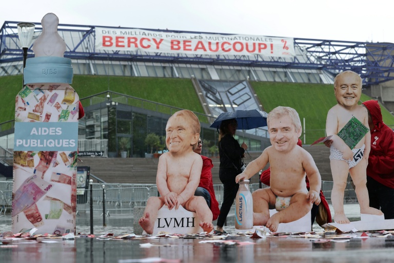 Des silhouettes de bébé arborant le visage des patrons de LVMH, Bernard Arnault, de Lactalis, Emmanuel Besnier, et de ST Microelectronics, Jean-Marc Chery, installés par des militants d'Attac France devant l'Accor Arena, près du ministère de l'Economie, à Paris, pour protester contre les subventions aux multinationales, le mardi 2 juin 2026 