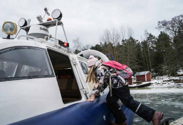 Une écolière embarque à bord d'un aéroglisseur pour rentrer de l'école, le 3 mars 2026 à Paragas, en Finlande
