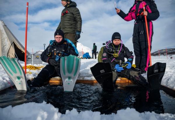 Des plongeurs participent à un stage scientifique de plongée polaire, le 14 mars 2026 sur le lac de Kilpisjärvi, à l'extrême nord-ouest de la Finlande
