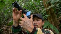 Octavius, villageois indonésien et ancien braconnier, utilise un téléphone portable équipé d’un téléobjectif pour prendre des photos d’animaux sauvages dans une forêt près du village de Labian, à Kapuas Hulu, à Bornéo, le 2 septembre 2026