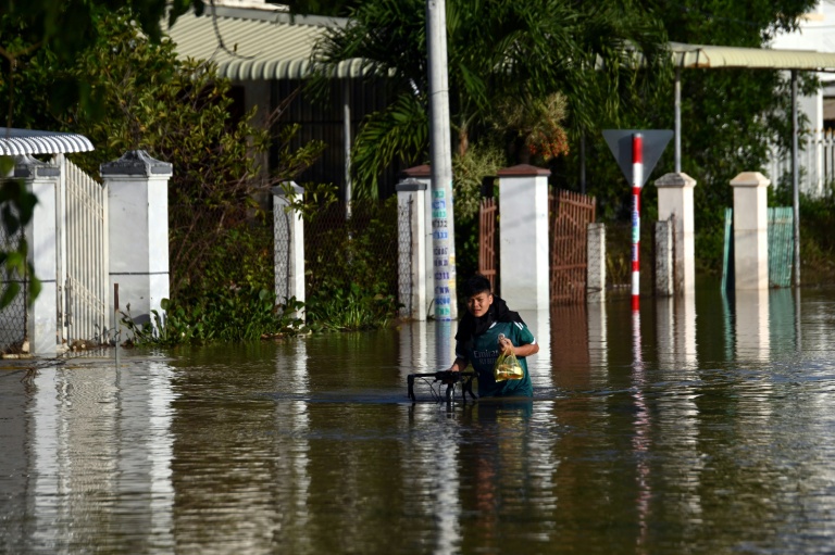 Un homme avance avec son vélo dans une rue inondée de Lam Dong, au Vietnam, le 5 décembre 2025