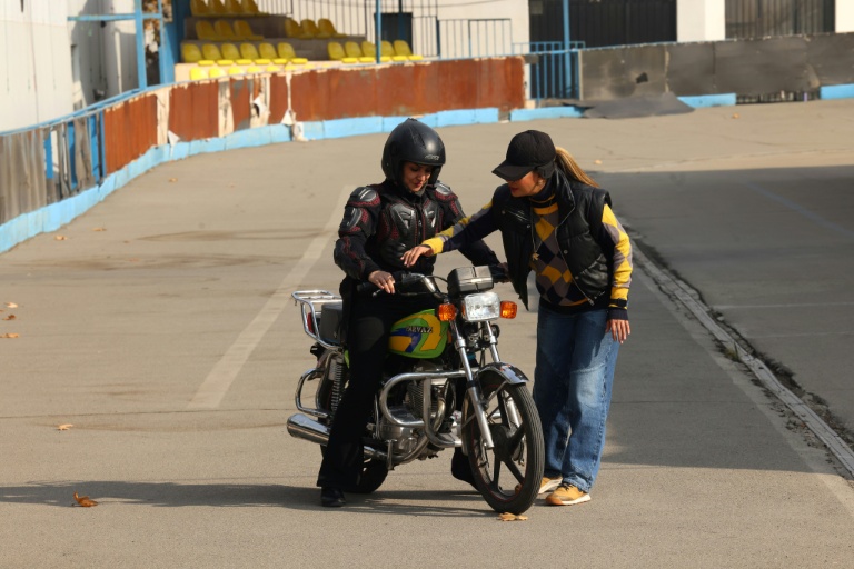 La monitrice Maryam Ghelich (g) pendant un cours de conduite avec son élève Leila dans un centre d'entraînement du nord de Téhéran, le 7 décembre 2025 en Iran
