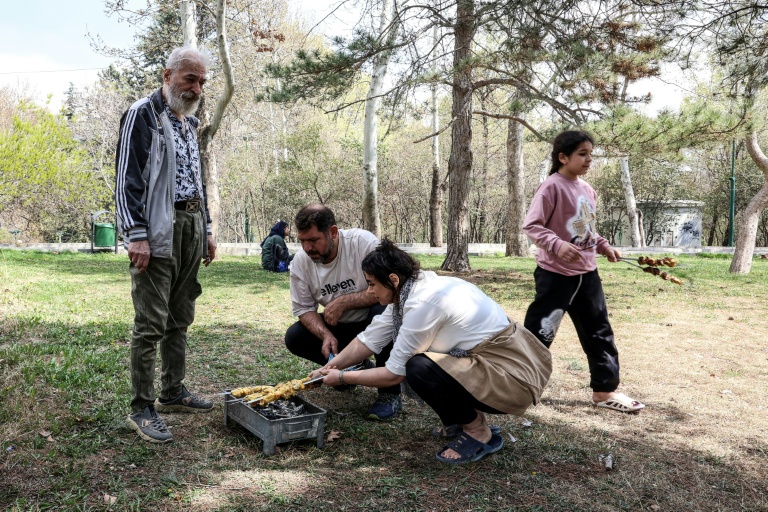 Des Iraniens préparent un barbecue au parc Mellat de Téhéran, le 2 avril 2026, à l'occasion de la 