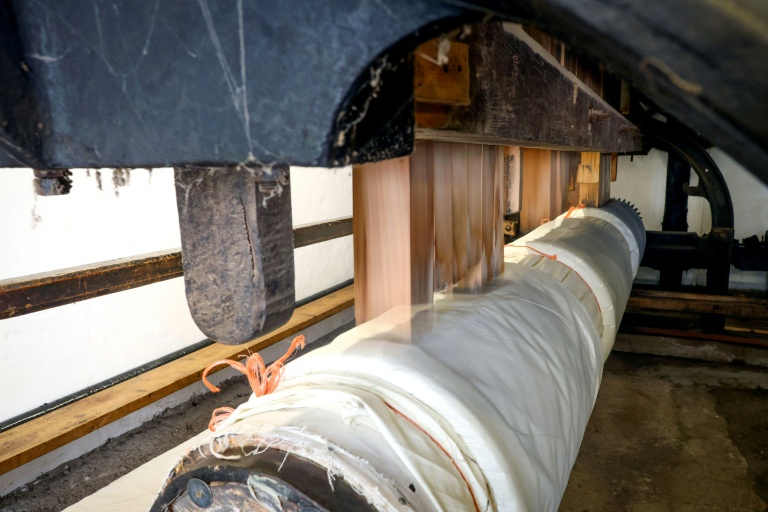 Des battoirs frappent des pans de tissu en lin, afin de le rendre plus solide et brillant, dans un atelier à Upperlands, en Irlande du Nord, le 4 septembre 2025