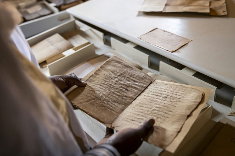 Mohamed Ben Baty contemple un très ancien manuscrit, le 4 avril 2025, dans la ville médiévale de Oualata, en Mauritanie