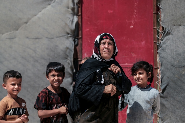 Une femme kurde syrienne déplacée, originaire de la ville de Ras al-Aïn, avec des enfants dans le camp de déplacés d'al-Talaeh, à Hassaké, dans le nord-est de la Syrie, le 23 juillet 2026