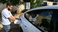Ahmad al-Lahham, chauffeur pour l'une des principales applications de taxis "Yalla Go", au volant son véhicule hybride rechargeable à Damas, le 25 octobre 2026 en Syrie