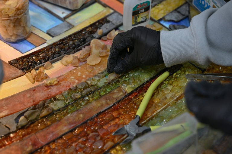 Une employée du groupe Amber Galbine travaillant l'ambre pour en faire des bijoux et des souvenirs à vendre, dans la région ukrainienne de Rivné, le 10 mai 2026