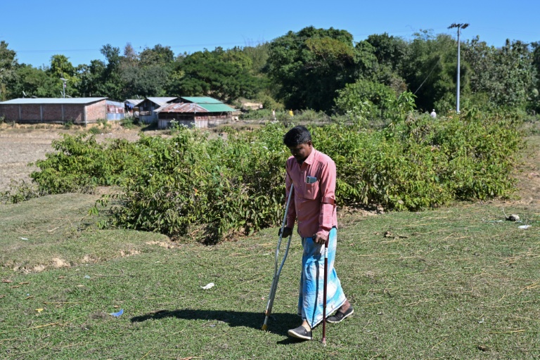 Ali Hossain, un Bangladais de 40 ans qui a perdu une jambe à cause d’une mine lorsqu'il ramassait du bois, regagne sa maison dans le district de Bandarban le 19 décembre 2025