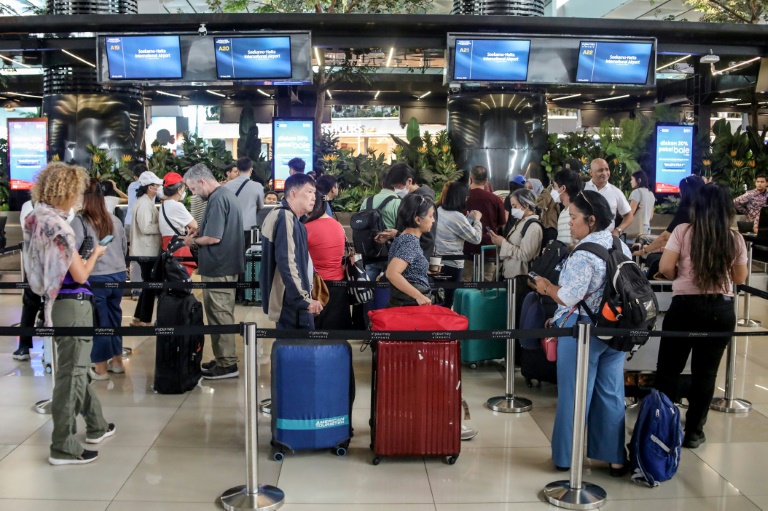 Des voyageurs bloqués à l'aéroport Soekarno-Hatta de Tangerang font la queue pour demander le remboursement de leurs billets après l'annulation de vols réguliers due à l'éruption du volcan Anak Krakatoa, le 6 septembre 2026 en Indonésie