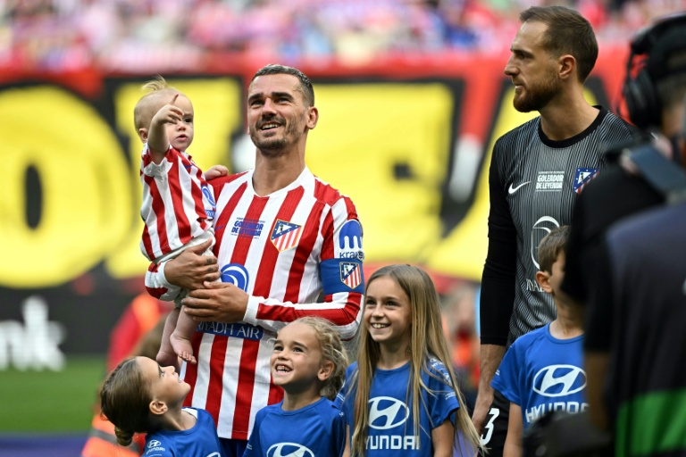 L'attaquant français de l'Atlético Madrid Antoine Griezmann porte sa fille Shai avant le début du match de Liga contre Gérone, le 17 mai 2026 au Metroplitano