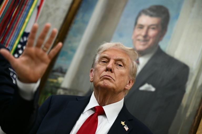 Le président américain Donald Trump devant un portrait de l'ex-président républicain Ronald Reagan, dans le Bureau ovale de la Maison Blanche, le 30 septembre 2025