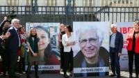 Cécile Kohler (3e G) et Jacques Paris (2e D) devant leurs portraits décrochés des grilles de l'Assemblée nationale, à Paris le 14 avril 2026