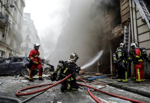 Des pompiers éteignent un incendie à la suite de l'explosion d'une boulangerie, à l'angle des rues Sainte-Cécile et de Trévise, dans le centre de Paris, le 12 janvier 2019