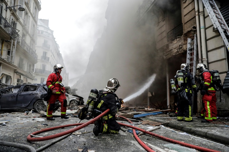 Des pompiers éteignent un incendie à la suite de l'explosion d'une boulangerie, à l'angle des rues Sainte-Cécile et de Trévise, dans le centre de Paris, le 12 janvier 2019