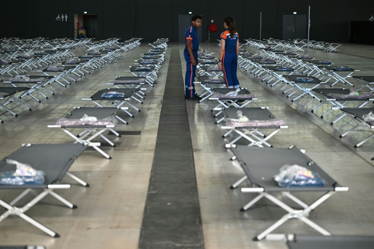 Des membres de la protection civile préparent des lits pour accueillir les personnes déplacées par le mégafeu en Gironde, le 28 juillet 2026 à Aussonne, près de Toulouse 