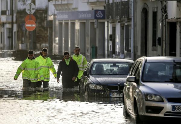 Des employés municipaux dans une rue inondée à Alcacer do Sal, dans le sud du Portugal, le 5 février 2026